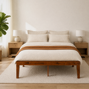 Airy room | Straight-on bedroom view with the platform bed, light walls, oak nightstands, and a leafy plant
