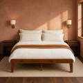 Clay room | Straight-on bedroom view against a clay-toned wall with brass sconces and dark nightstands