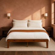 Clay room | Straight-on bedroom view against a clay-toned wall with brass sconces and dark nightstands
