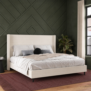 Forest-green bedroom | Textured ivory canvas wingback bed with preserved bedding and a burgundy rug