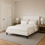 In scale | Ivory wingback bed beside a full interior doorway