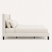 Studio side | Right profile of Ivory upholstered bed with wingback headboard and black legs