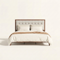 Studio front | Walnut platform bed with square-tufted light linen headboard and tapered legs