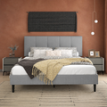 Terracotta bedroom | Light Gray low profile platform bed with a five-channel headboard, patterned bedding, dark nightstands, and a sand linear rug