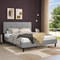 Aubergine bedroom | Light Gray low profile platform bed with a five-channel headboard, patterned bedding, bronze window panels, and a cream geometric rug