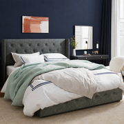 Indigo bedroom | dark charcoal tufted wingback bed with mint and white bedding beside a black console