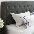 Headboard detail | dark charcoal button-tufted wingback headboard corner with white pillows
