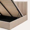Lift detail | Close view of the photographed black gas strut, wood slat deck, and beige upholstered rail