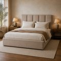 Room 1 angle | Three-quarter view of the beige upholstered bed in the limewash bedroom with oak nightstands