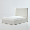 Studio angle | Ivory canvas wingback bed with a low upholstered plinth