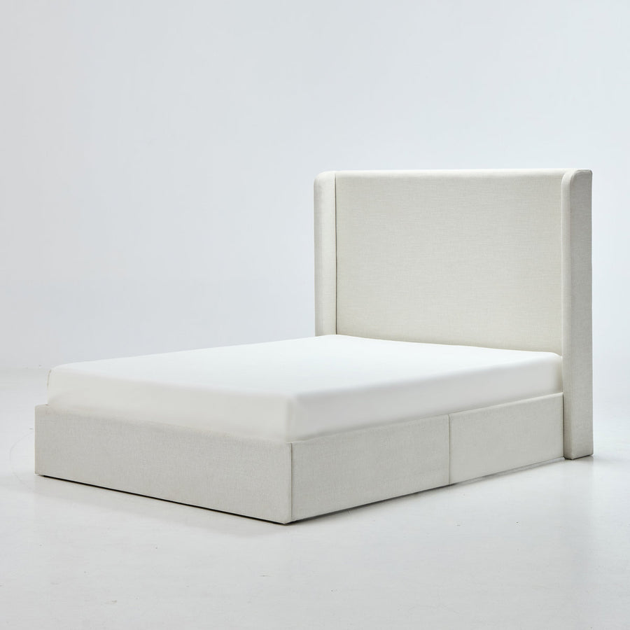 Studio angle | Ivory canvas wingback bed with a low upholstered plinth