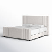 Studio angle | Cream velvet channel tufted bed from the front left on a white seamless background