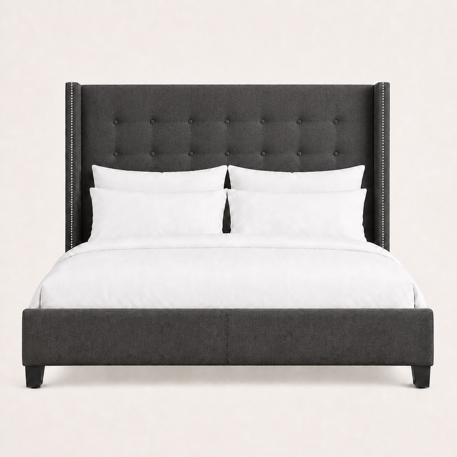 Studio front | Charcoal button-tufted wingback bed with squared wings, silver nailhead trim, and a low upholstered footboard