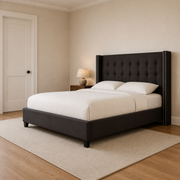 Scale | Charcoal wingback bed in a compact cream bedroom with a complete doorway at left for scale