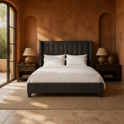 Terracotta bedroom | Charcoal wingback bed in a terracotta room with garden doors, walnut nightstands, and a plain flax rug