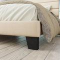 Foot and rail detail | Cream upholstered rail above a dark tapered foot