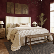 Burgundy bedroom angle | cream velvet channel wingback bed against oxblood walls