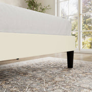 Low rail detail | cream upholstered bed rail and black leg beside a window