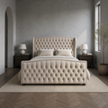 Blue-gray bedroom | cream velvet tufted wingback bed with dark nightstands