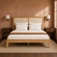 Room 3 | Front view against a clay wall with brass sconces, dark nightstands, rug, and the two-panel natural rattan headboard.