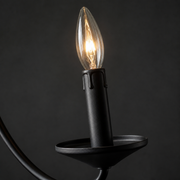 Hardware | close view of a black candle cup, socket, and clear flame-shaped candelabra bulb