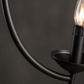 Material | close view of the matte black curved arm, candle cup, and clear flame-shaped bulb