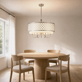 In a room | brushed-nickel quatrefoil drum chandelier hanging over a round oak dining table