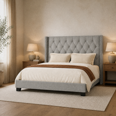 Room 1 angle | Gray upholstered wingback headboard and footboard shown from the front corner with cream bedding.