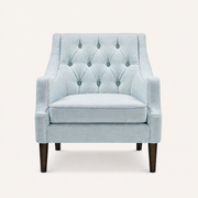 Studio front | pale ice-blue woven wingback chair with ten fabric-covered buttons, piped seat cushion, and dark tapered wood legs