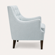 Studio side | left rear profile of the pale ice-blue wingback chair showing the tall back slope and dark tapered legs