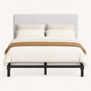 Front | Straight-on studio view of the upholstered rectangular headboard above the black bed frame on a pale backdrop