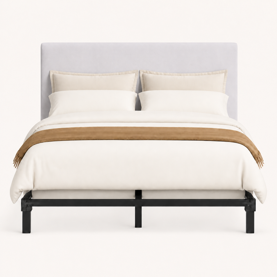 Front | Straight-on studio view of the upholstered rectangular headboard above the black bed frame on a pale backdrop