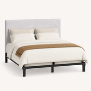 Studio | Three-quarter studio view showing the upholstered headboard, bedding, and black bed frame on a pale backdrop