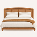 Front | Straight-on studio plate of the whole headboard on a pale backdrop, showing the arched top and cane weave
