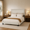 Angle | Three-quarter view of the cream upholstered bed with wood nightstands and window