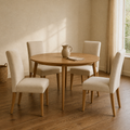 In a room | all four matching beige linen dining chairs at a plaster dining room's table, low golden afternoon light from the right