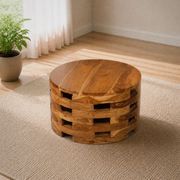 Angle in a room | raised three-quarter view of the round wood coffee table on an oatmeal rug in a bright living room