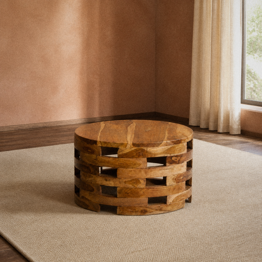 In a room | round honey-brown wood coffee table with open slat drum base in a clay-toned room with dark wood floor
