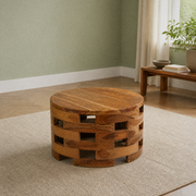 In a room | round wood coffee table on an oatmeal rug in a sage green room with a window and side table