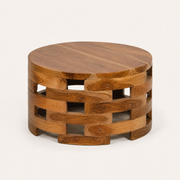 Angle | raised three-quarter view of the round wood coffee table showing its solid top and open slat base