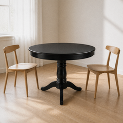 Angle | same dining room, table at a true three-quarter so the round top and pedestal feet both read