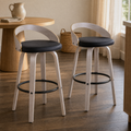 In a dining nook | both stools by a round table set with a stoneware pitcher and linen napkin, warm afternoon light