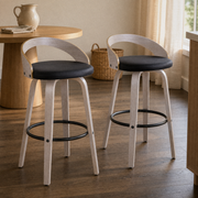 In a dining nook | both stools by a round table set with a stoneware pitcher and linen napkin, warm afternoon light
