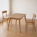 Angle | same dining room, table at a three-quarter so the top, apron, and splayed tapered legs all read
