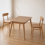 Angle | same dining room, table at a three-quarter so the top, apron, and splayed tapered legs all read