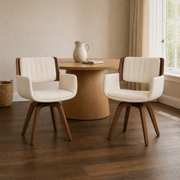 In a room | both beige swivel armchairs at a round table in a warm plaster dining room, window at right