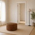 In scale | 32-inch round woven rattan coffee table beside a fully visible interior doorway