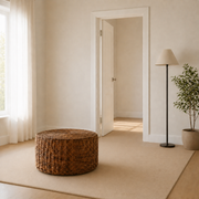 In scale | 32-inch round woven rattan coffee table beside a fully visible interior doorway