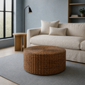 Cool blue living room angle | woven rattan coffee table from a higher three-quarter view before an oatmeal sofa