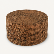 Three-quarter | round woven rattan coffee table showing the coiled top and cylindrical body